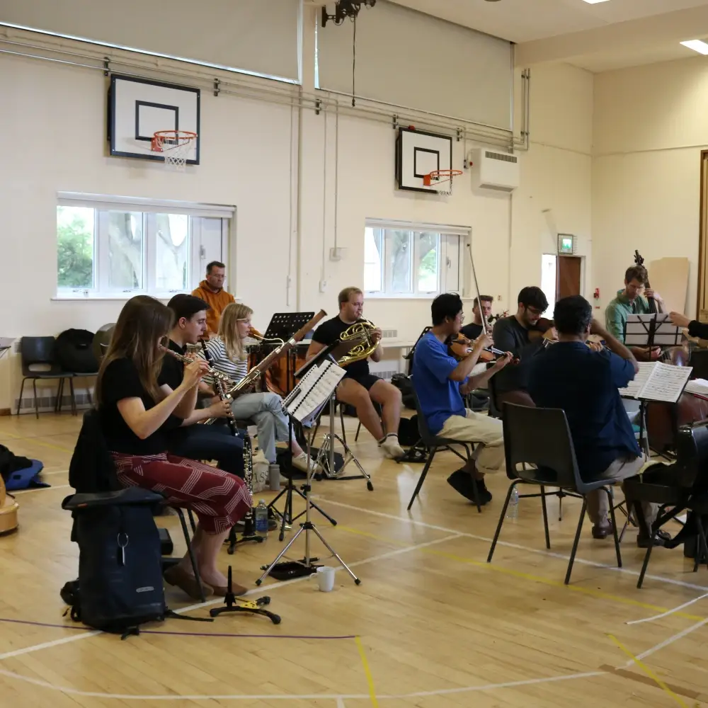 An orchestra rehearsing Carmen under the direction of conductor Olivia Clarke.