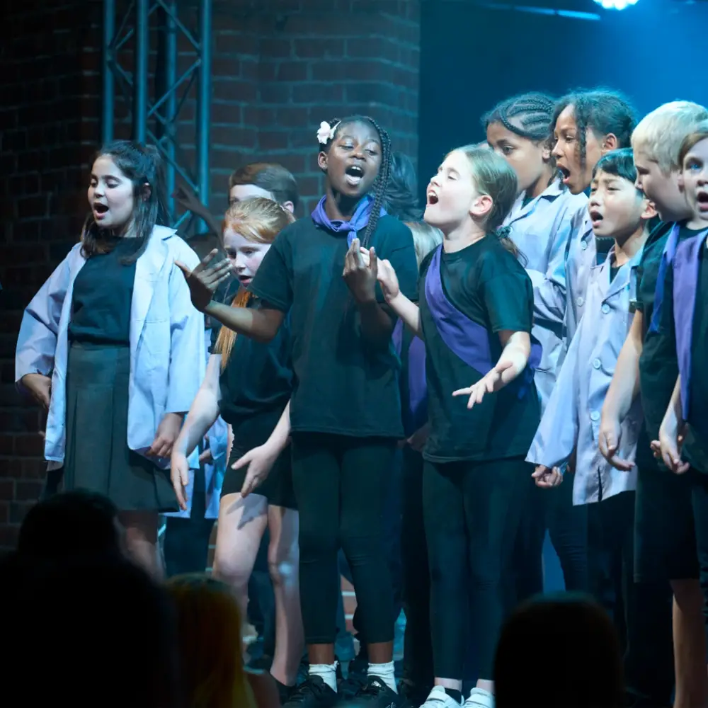 Children singing together on stage during IntoOpera’s Explorers school production.