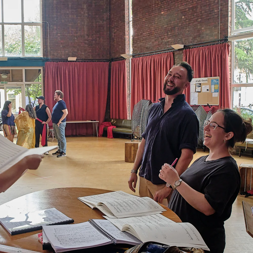 Opera performers rehearsing together with sheet music
