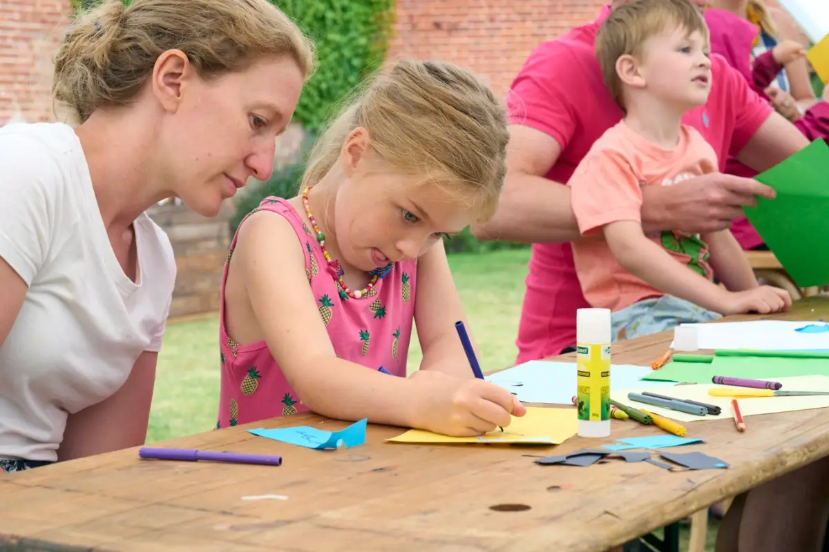 Child creating artwork at an outdoor IntoOpera activity