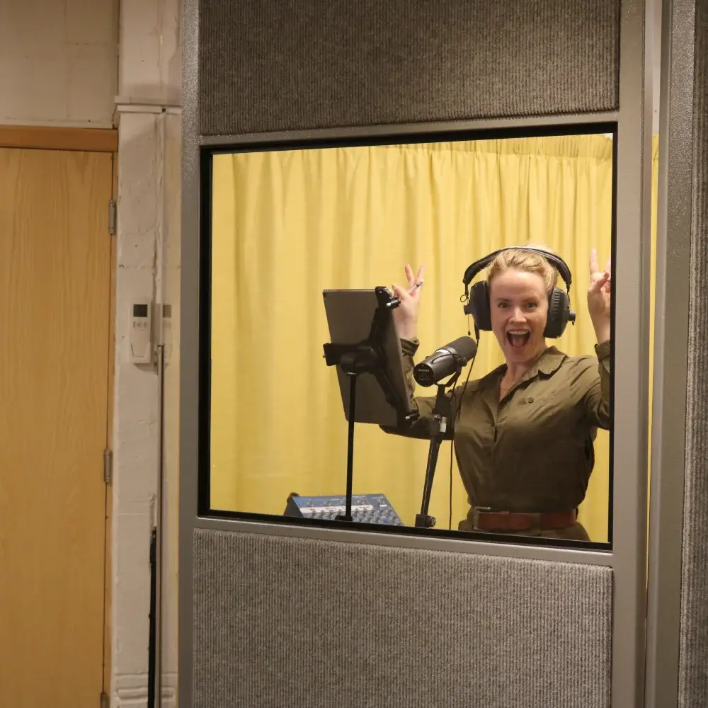 Opera singer recording vocals in a studio booth